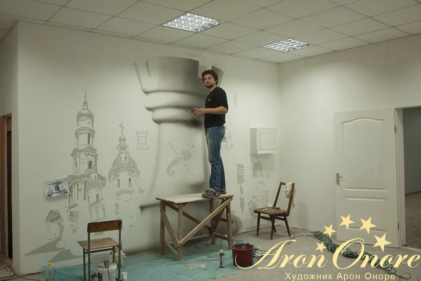 Художник рисует фигуры – шахматы на стене